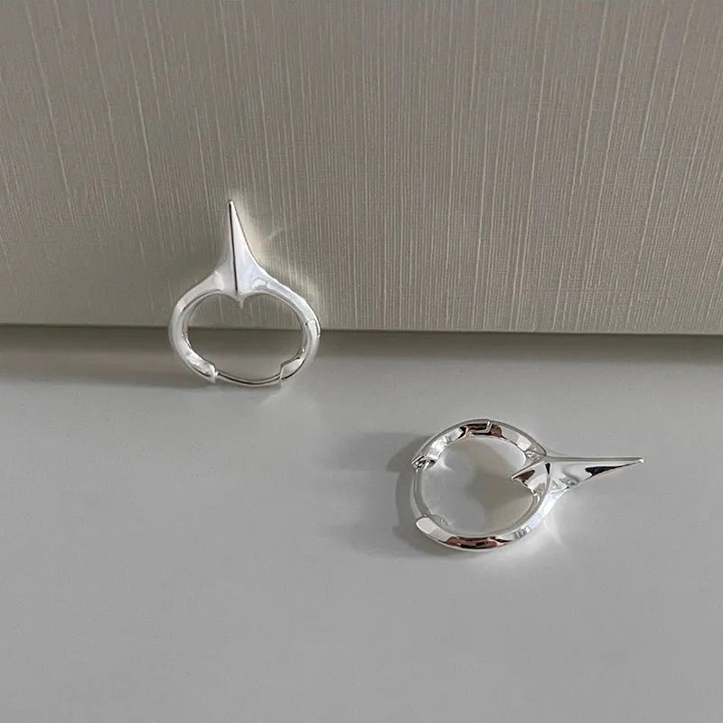 Geometric star ear clips with white gold electroplating on copper, showing secure clip mechanism and detailed star shape
