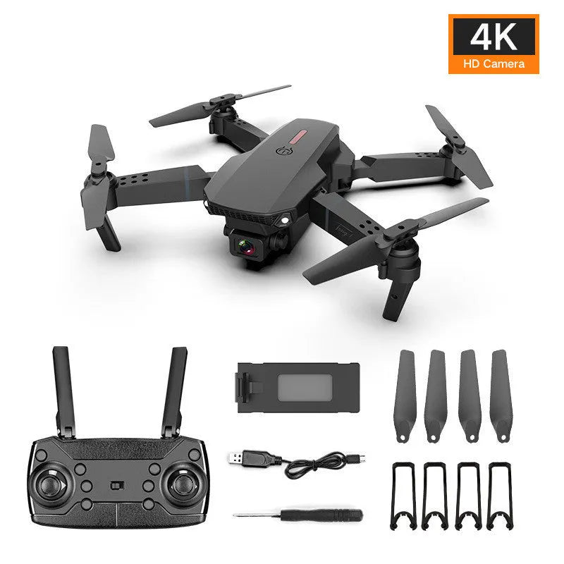 Grey foldable 4K aerial drone with dual cameras and remote control on a grassy field.