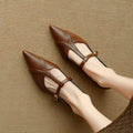 Brown women's rounded toe cowhide flat shoes with a low heel on a neutral background.