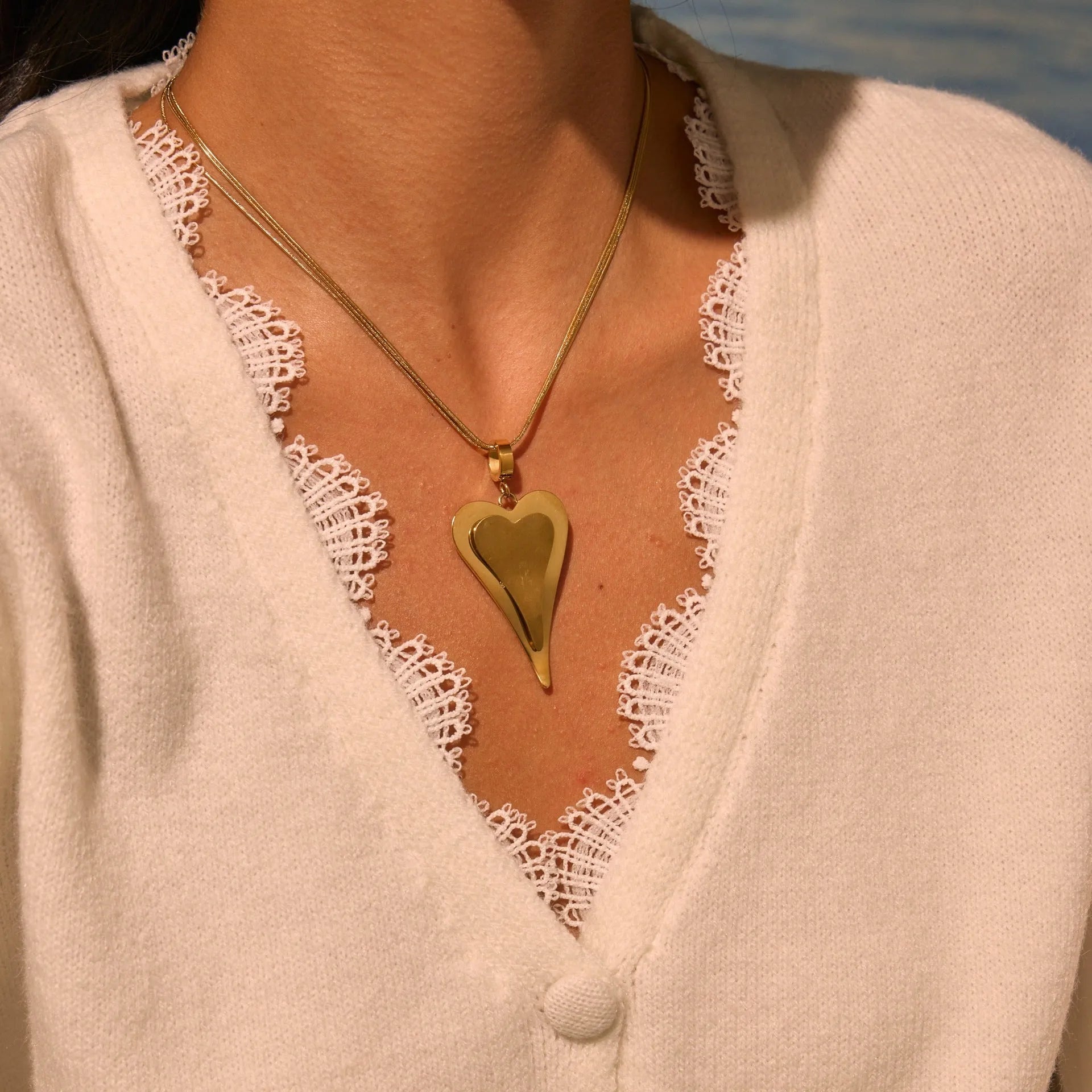 Geometric double heart pendant on a stainless steel snake bones chain necklace in gold or steel finish.