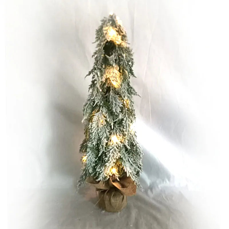 24-inch desktop Christmas tree with PE snow simulation and integrated lighting on wooden surface