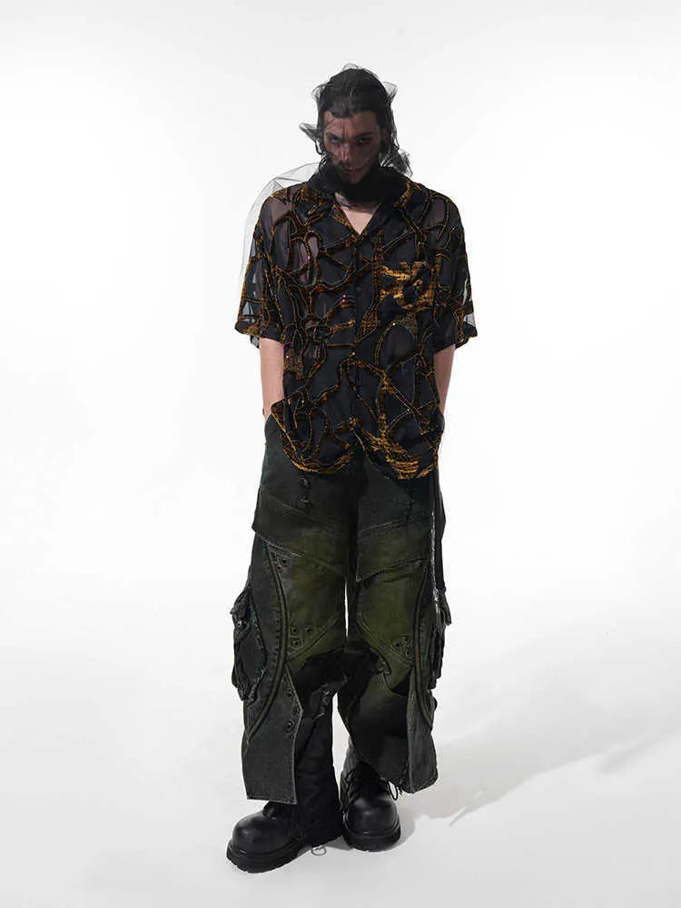 Man wearing a black translucent short-sleeved shirt with a snake pattern, featuring a lapel collar and loose fit.