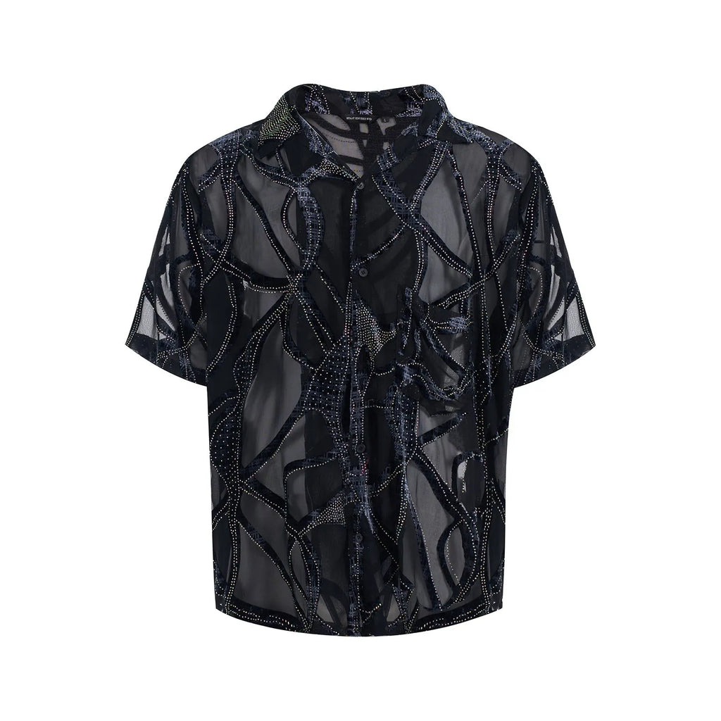 Man wearing a black translucent short-sleeved shirt with a snake pattern, featuring a lapel collar and loose fit.