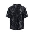 Man wearing a black translucent short-sleeved shirt with a snake pattern, featuring a lapel collar and loose fit.