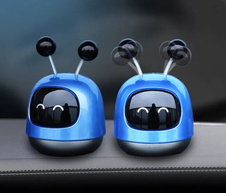 Blue robot car decorative ornament clipped to a car air vent as an aromatherapy diffuser.