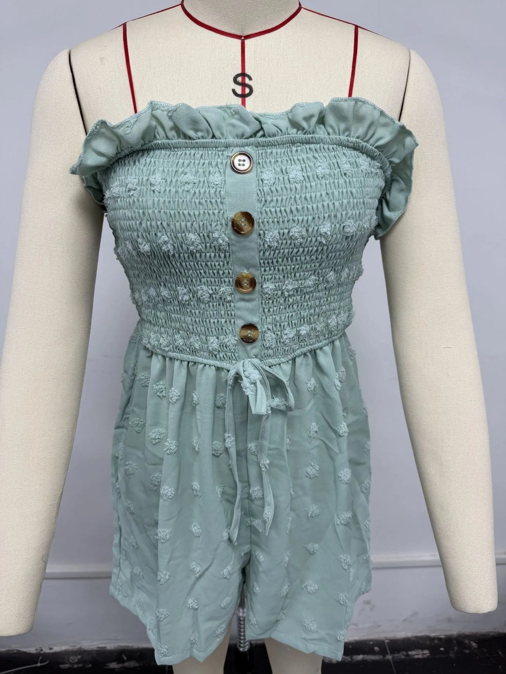 Women's blue off-shoulder sleeveless jumpsuit with button detail and mid-waist design on mannequin
