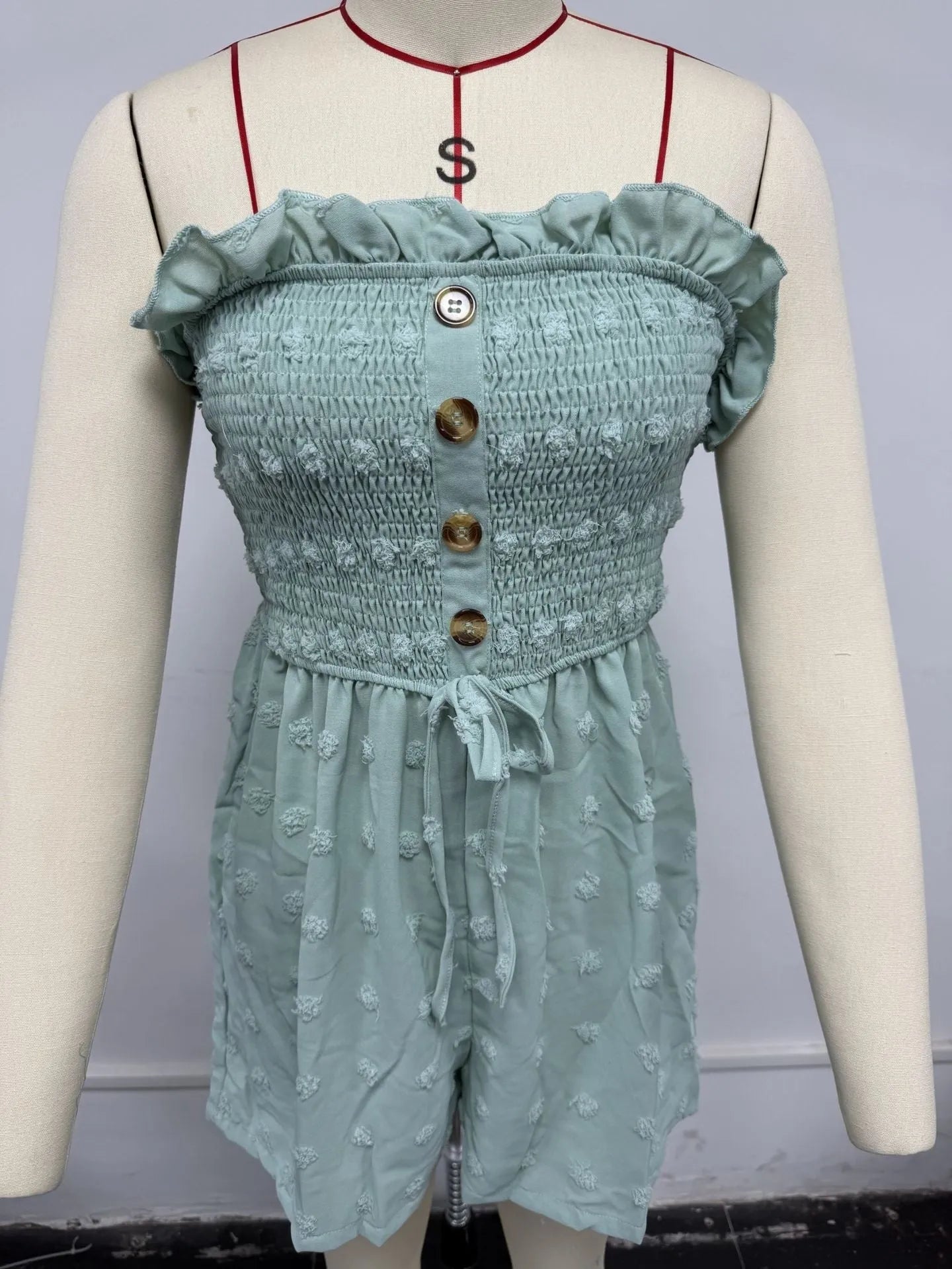 Women's blue off-shoulder sleeveless jumpsuit with button detail and mid-waist design on mannequin