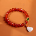 Chinese style geometric women's bracelet with red agate beads and a gold jade Maitreya Buddha pendant.