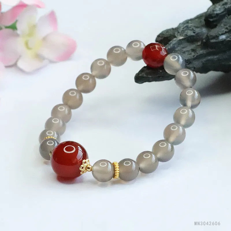 Natural smoky purple and red agate bracelet with 8mm geometric beads on a wrist.