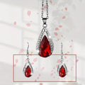 Black and red teardrop glass pendant necklace with matching earrings set on display