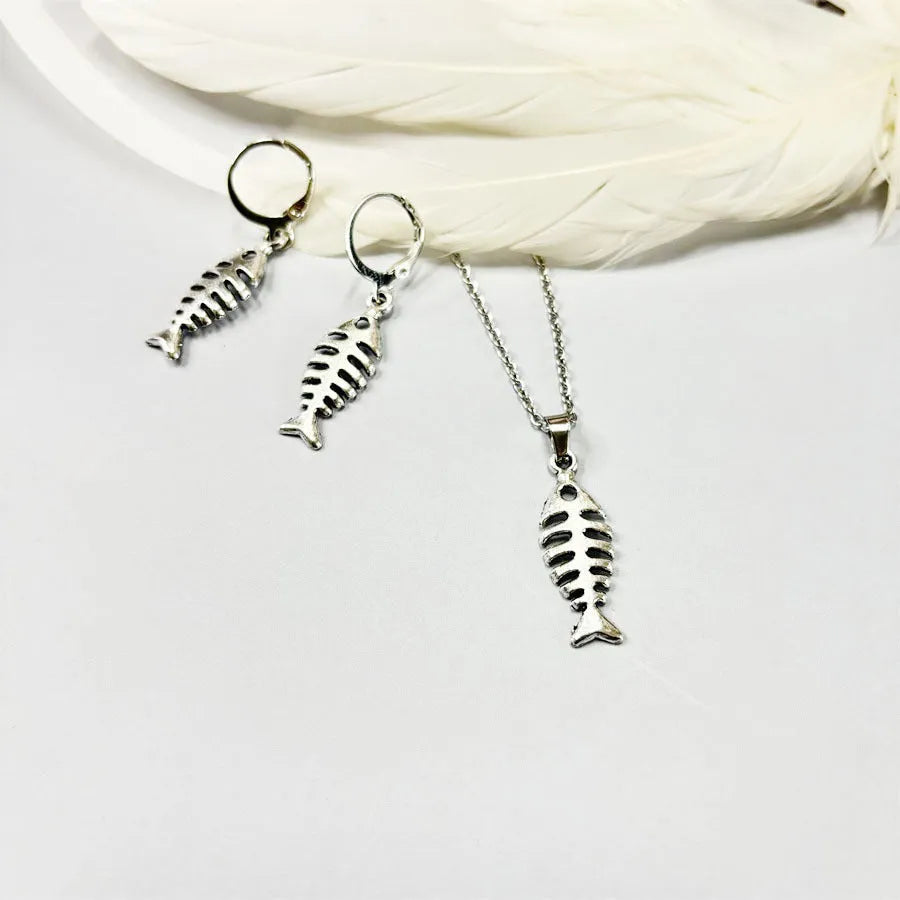 Fishbone pendant necklace with adjustable chain and matching retro earrings set on dark background