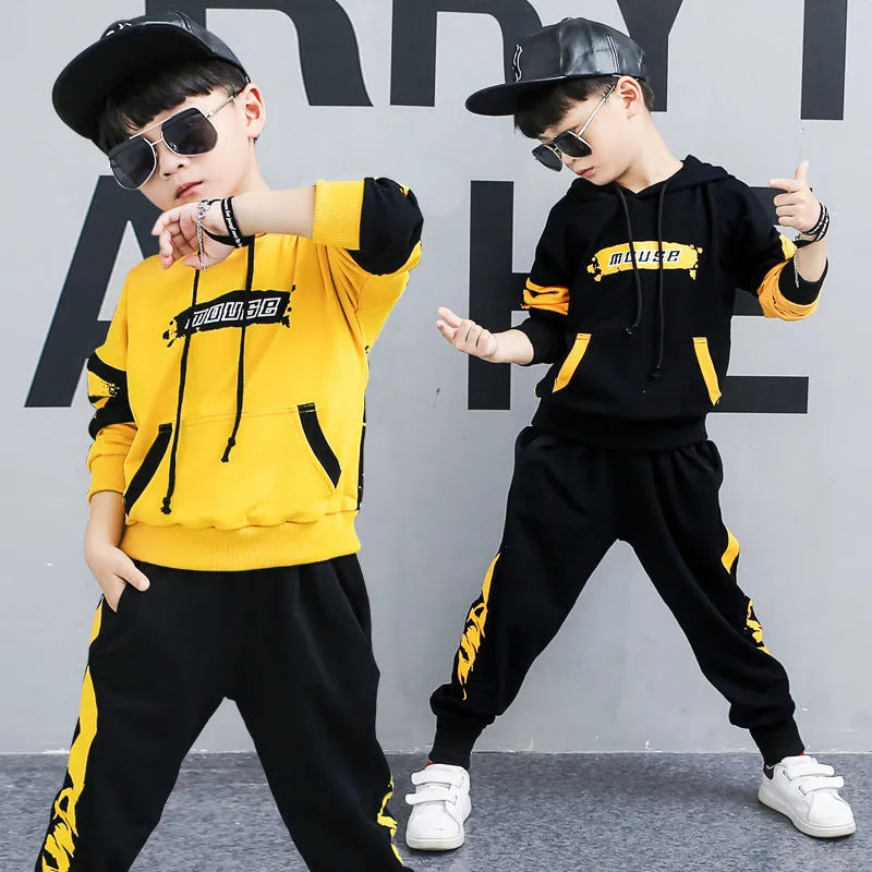 Boy's black and yellow hooded cotton sports suit trousers set on hanger, showing Korean style letter pattern.