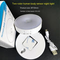 White circular LED motion night light with USB charging port, 86mm diameter, mounted with adhesive tape