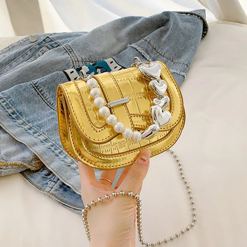 Laser Pearl Tote Saddle Girl Mini crossbody bag in gold colour showing horizontal square design and shoulder strap