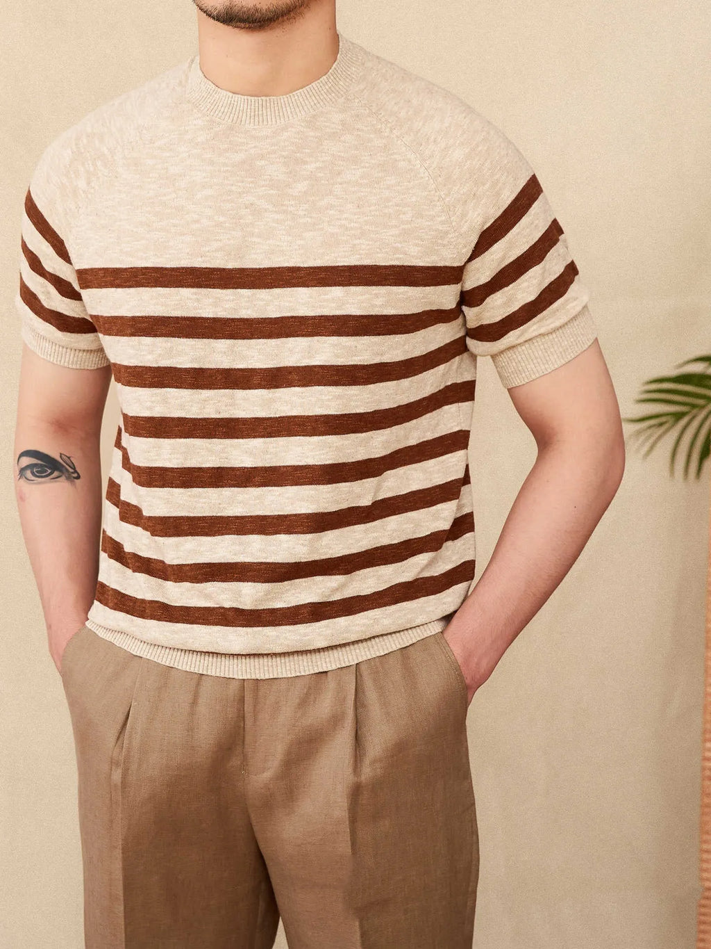 Man wearing a navy blue and white striped short sleeve linen-cotton blend t-shirt with a round neck.