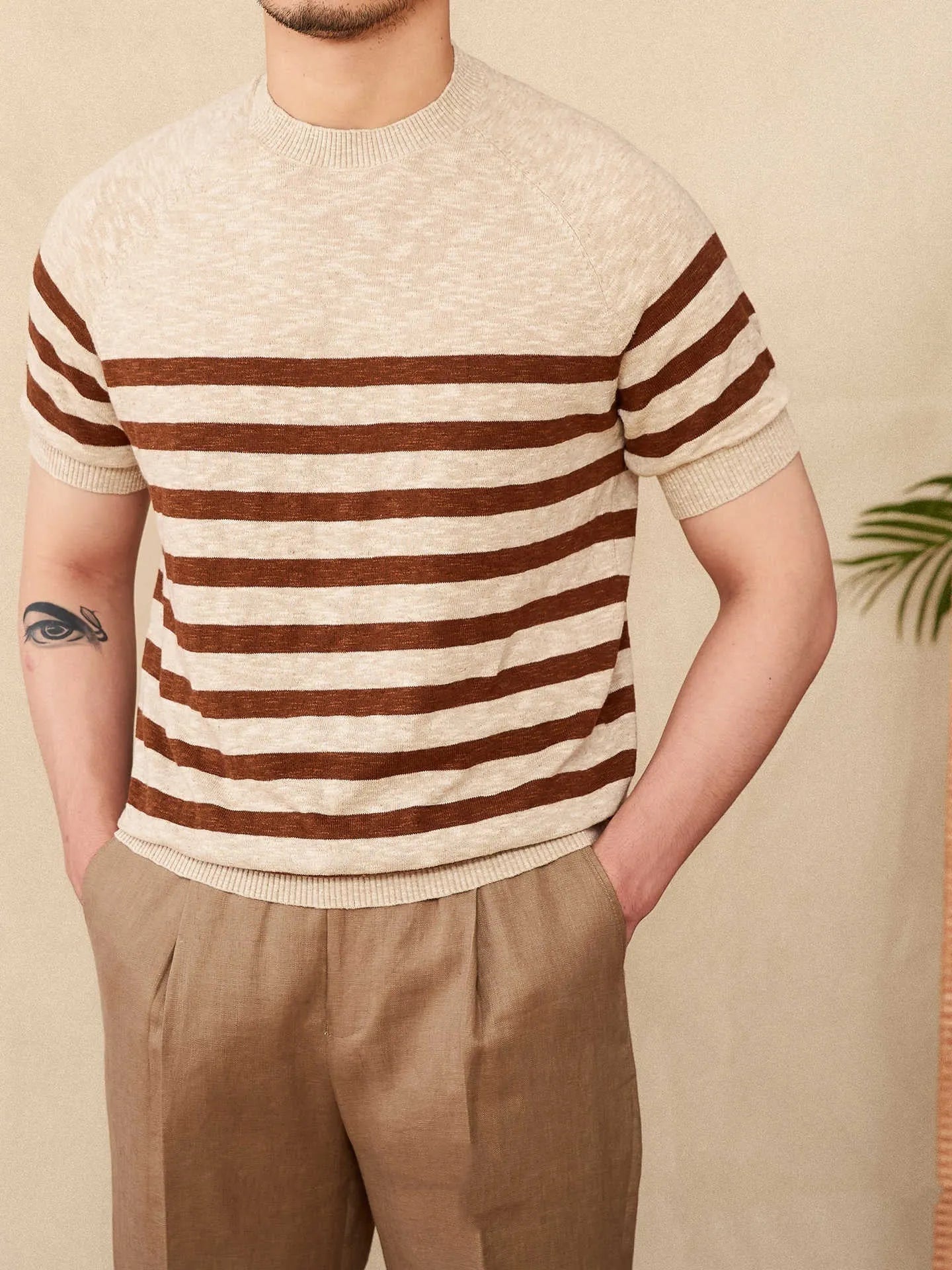 Man wearing a navy blue and white striped short sleeve linen-cotton blend t-shirt with a round neck.