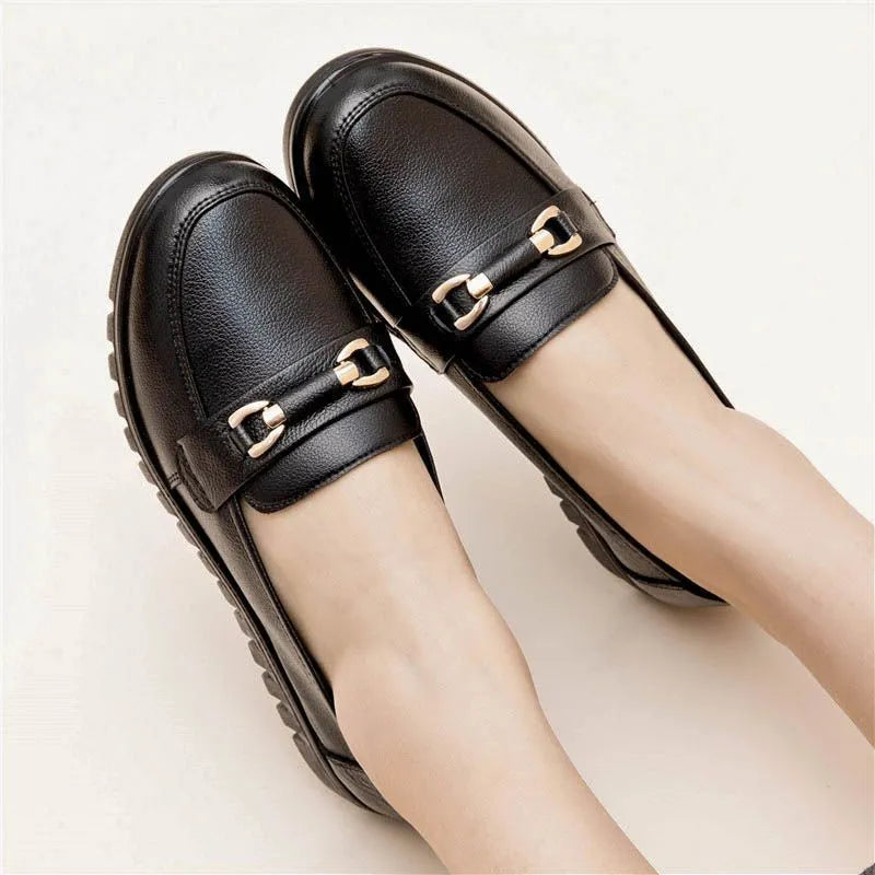 Black women's low-heel leather pumps with a round toe and soft rubber sole.