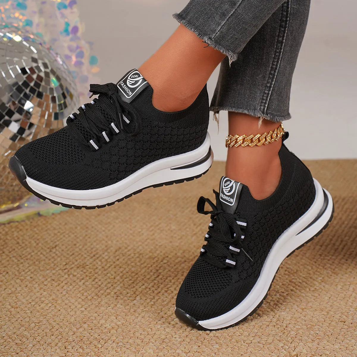 Women's black and white flat lace-up mesh sneakers on a white background