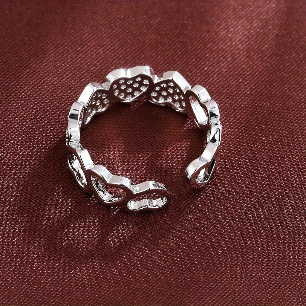 Adjustable geometric couples ring with love heart elements in gold or silver colour, showing opening mechanism