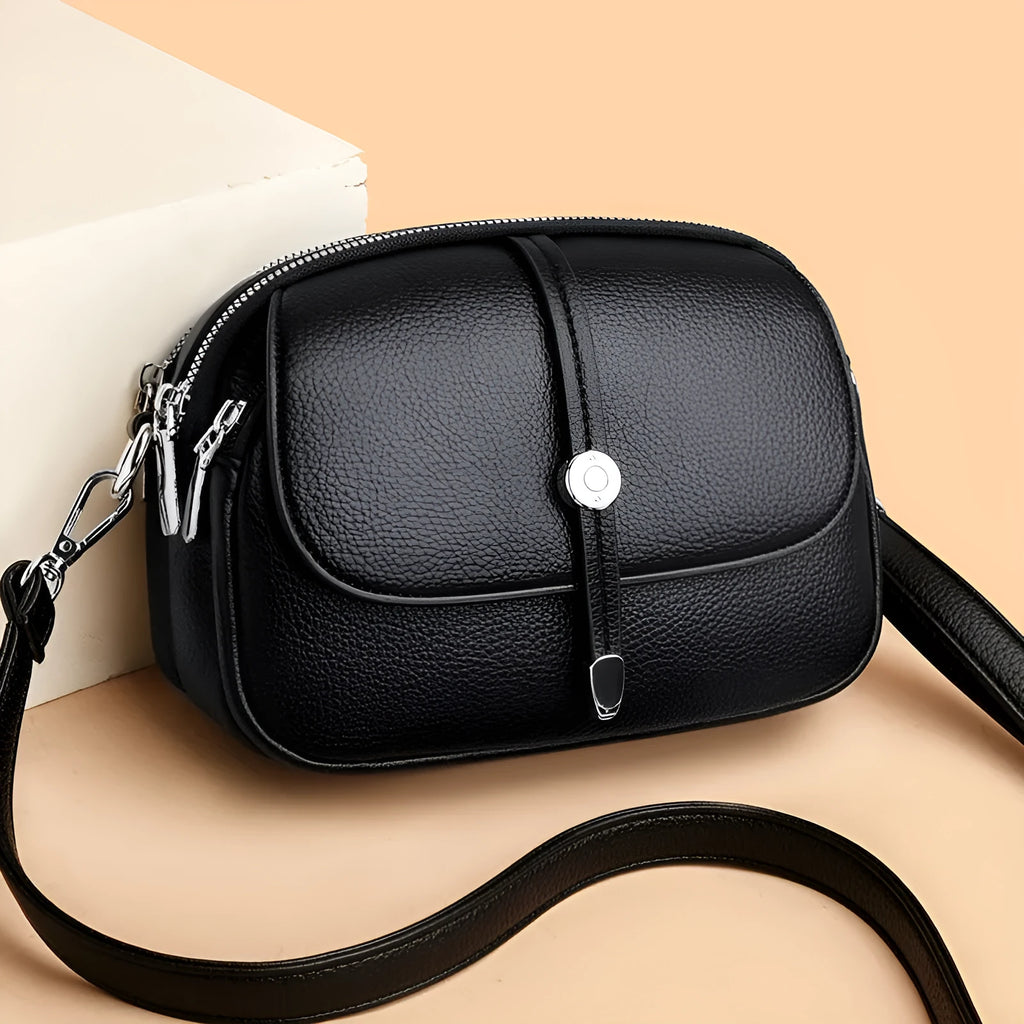 Women's soft PU oval crossbody shoulder bag with sewing thread detailing in dark brown