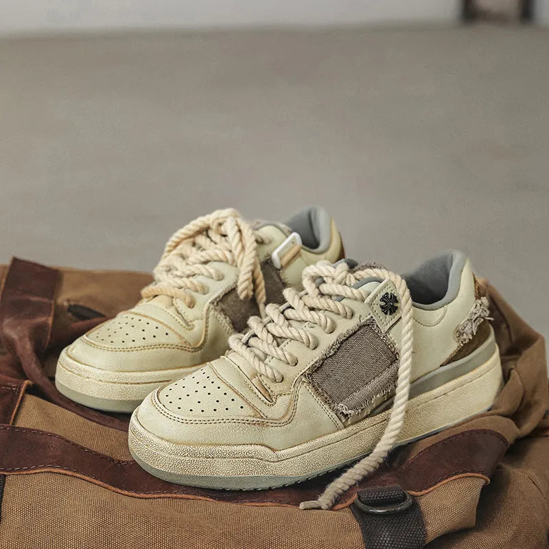 Beige low-top skateboard shoes with microfiber uppers, round toe, and lace-up closure on solid background
