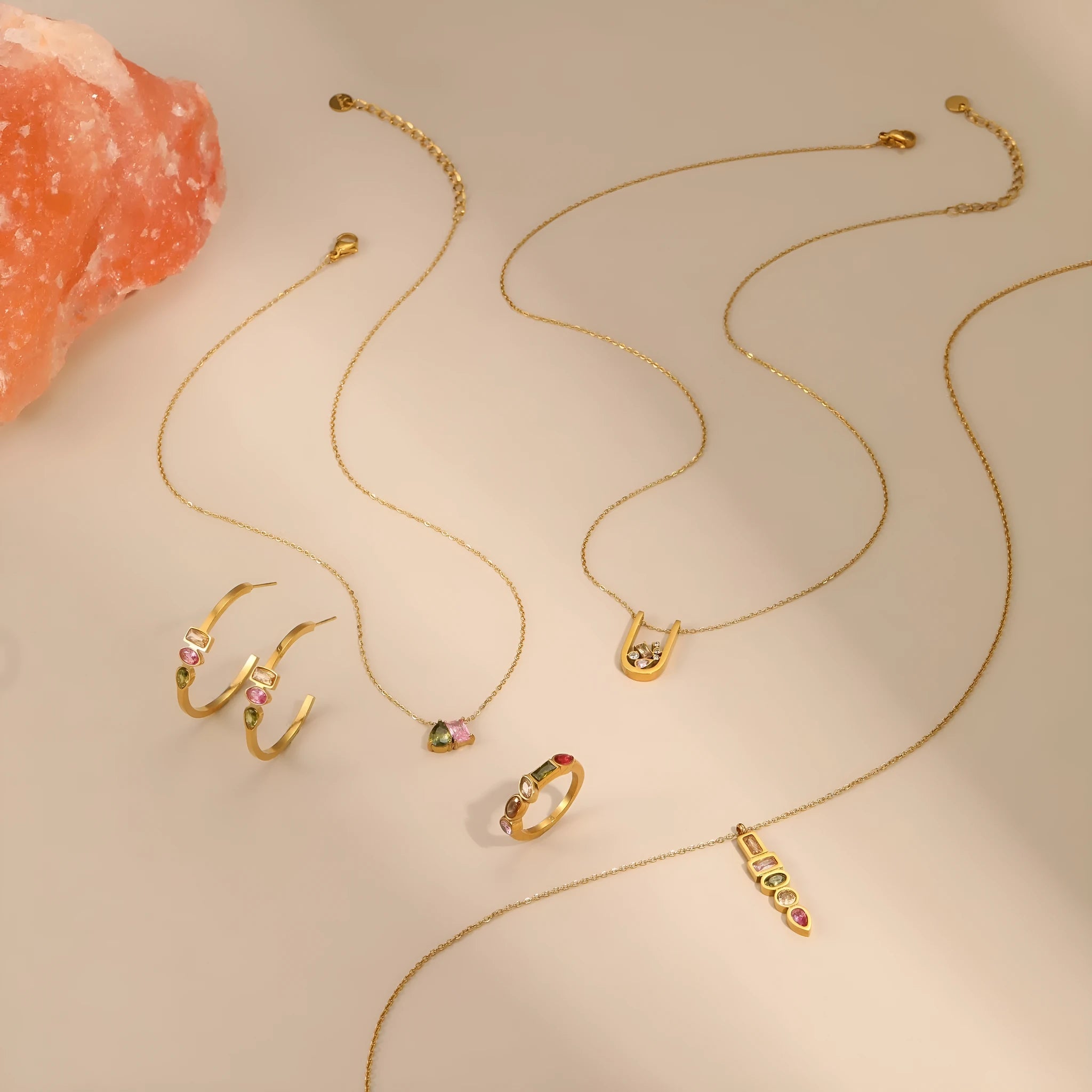 Geometric gold-plated stainless steel jewellery set featuring a necklace, ring, and earrings on a white background.