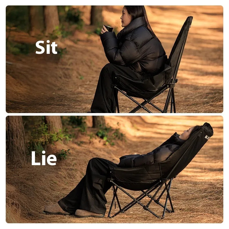 Black folding camping recliner with Oxford cloth seat, shown in outdoor setting