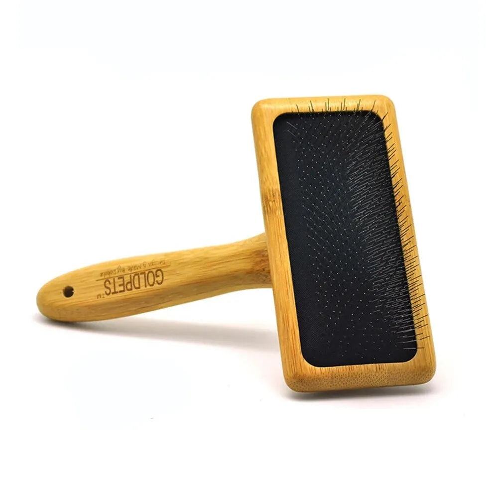 Goldpets bamboo wood pet slicker brush with stainless steel pins on a wooden table