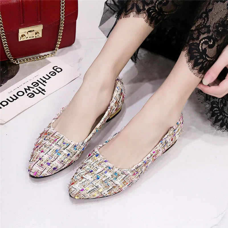 Women's black and white floral patterned canvas casual shoes with a pointed toe and flat rubber sole.