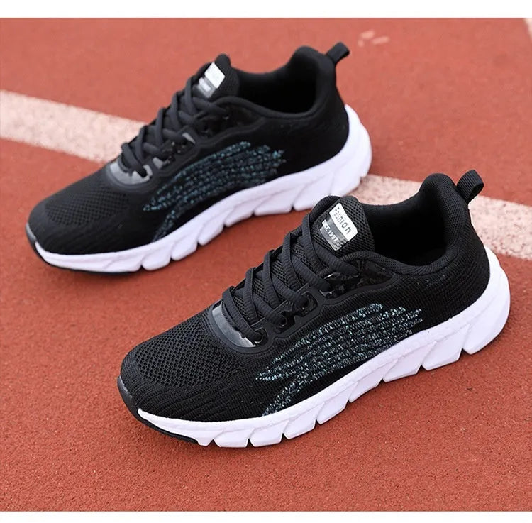 Women's low-cut black and white casual running sneakers with cross-strap detail and a lightweight MD sole.