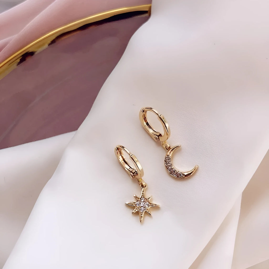 Pair of star moon pendant earrings in copper alloy with crystal detailing, shown in gold and silver options