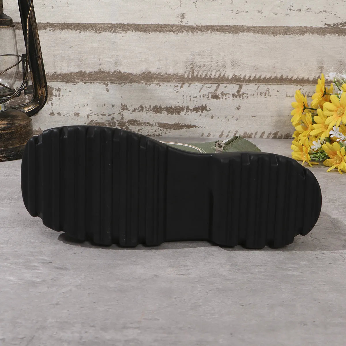 Women's black platform Martin boots with chunky heel and side zipper on a wooden floor