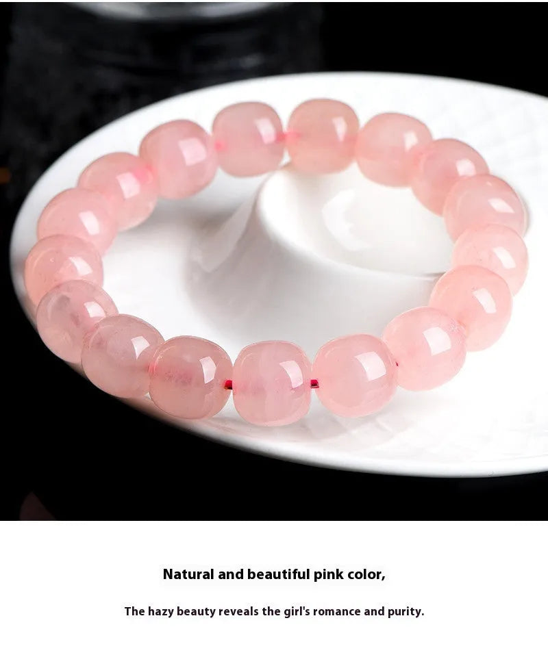 Natural pink crystal bracelet with 19 polished barrel-shaped beads on a wrist, showing geometric design.