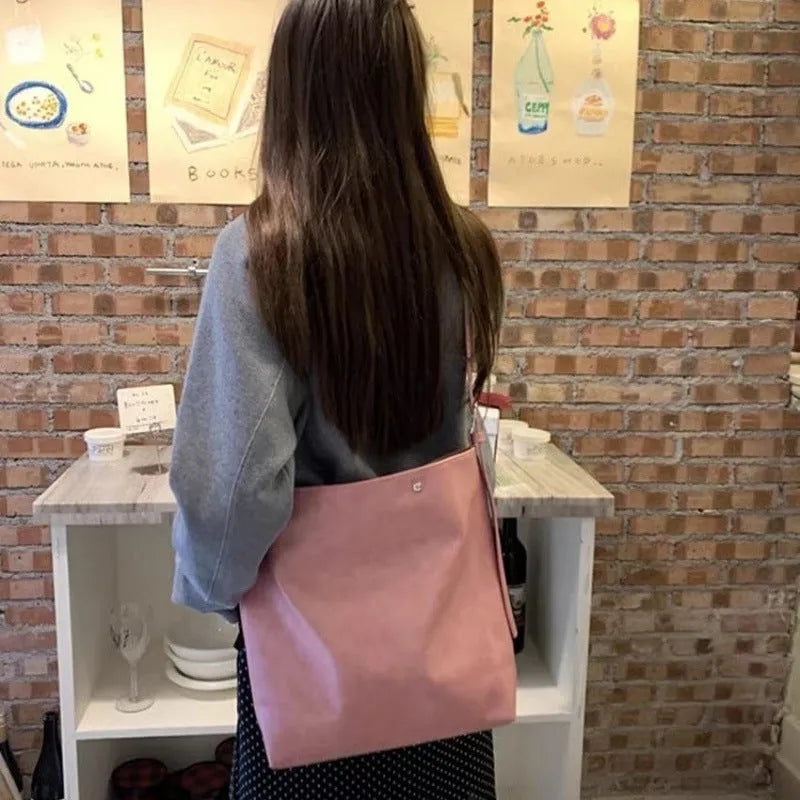 Pink corduroy one-shoulder commuter bag showing size and texture