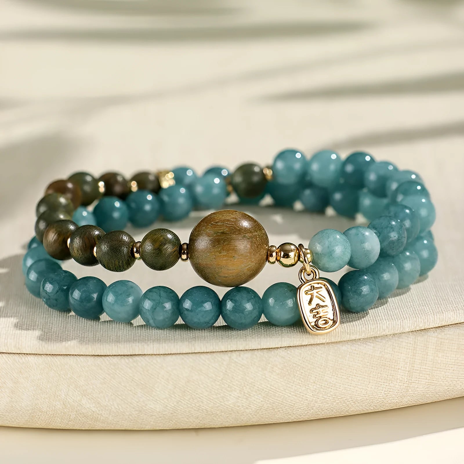 Blue natural stone beaded bracelet with golden sandalwood, guajacwood, or rosewood beads featuring fu and xi characters