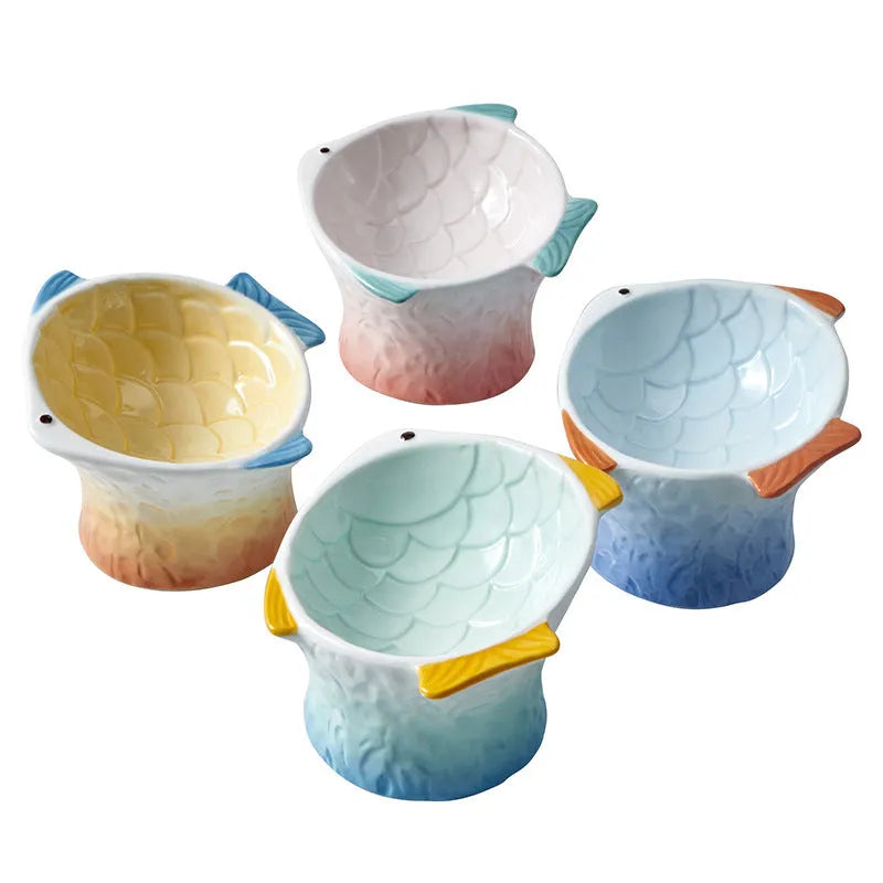 Blue fish-shaped ceramic cat bowl with 15-degree tilt angle on wooden surface