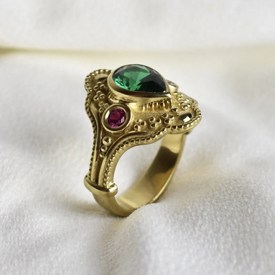 Gold-plated geometric fashion ring for women on grey background showing detailed design