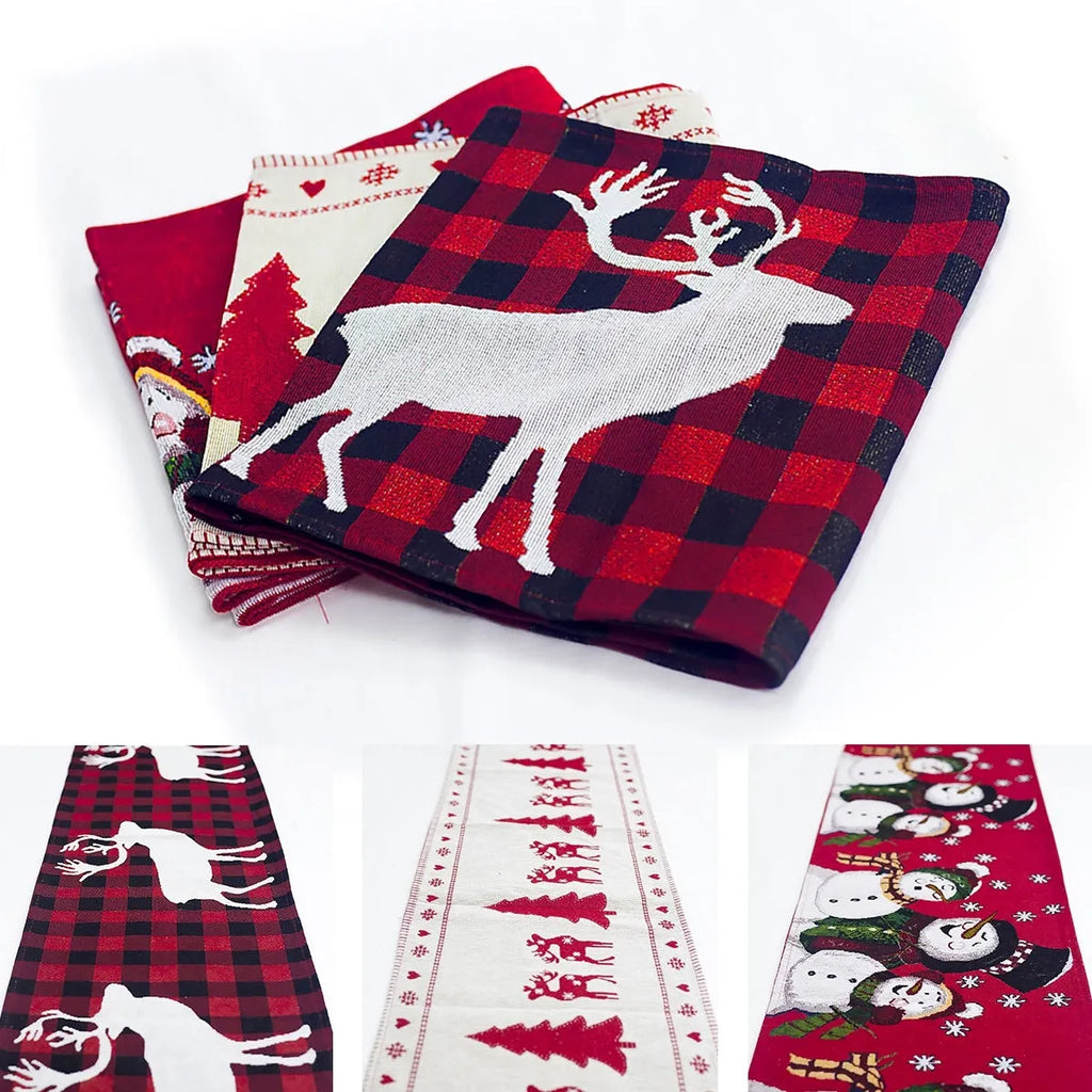 Red, white, and green Christmas table runner with elk and snowman print on a wooden dining table.