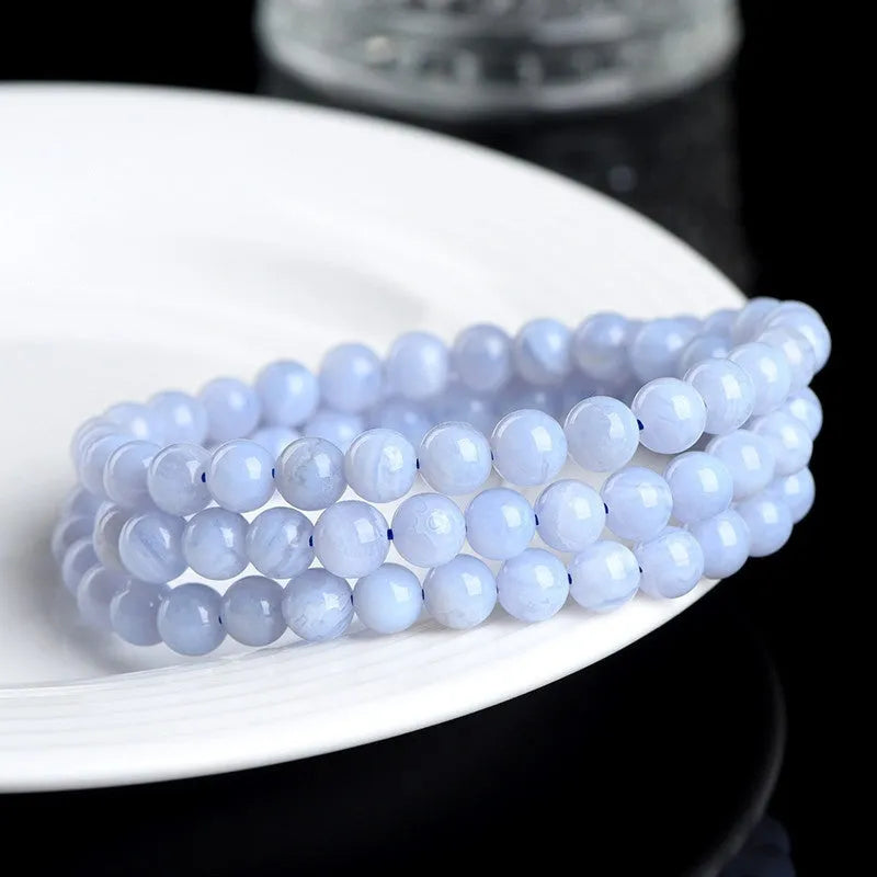 Blue agate bracelet with 6-6.8mm beads showing multi-circle pattern and scattered striped agate beads, Ruyi elements visible