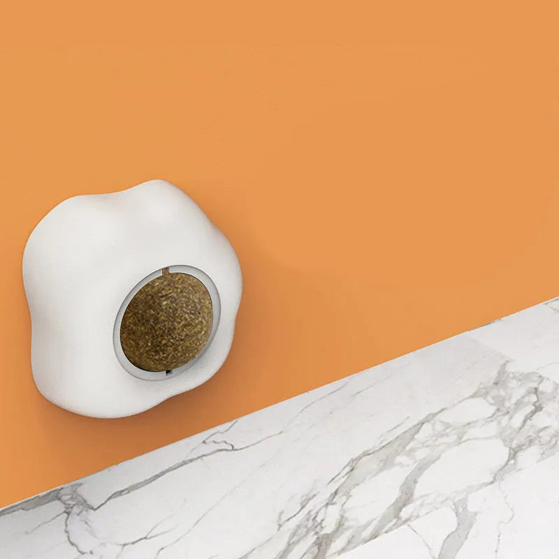 Catnip ball toy with 360-degree rotation mounted on wall, natural catnip filling visible through plush material