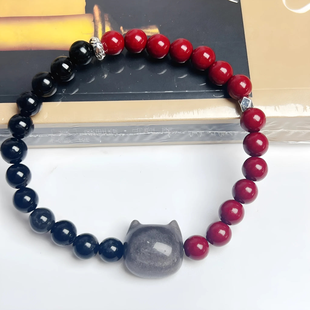 Handmade obsidian colour cat bracelet with carved black cat charm and colourful beads on black elastic cord