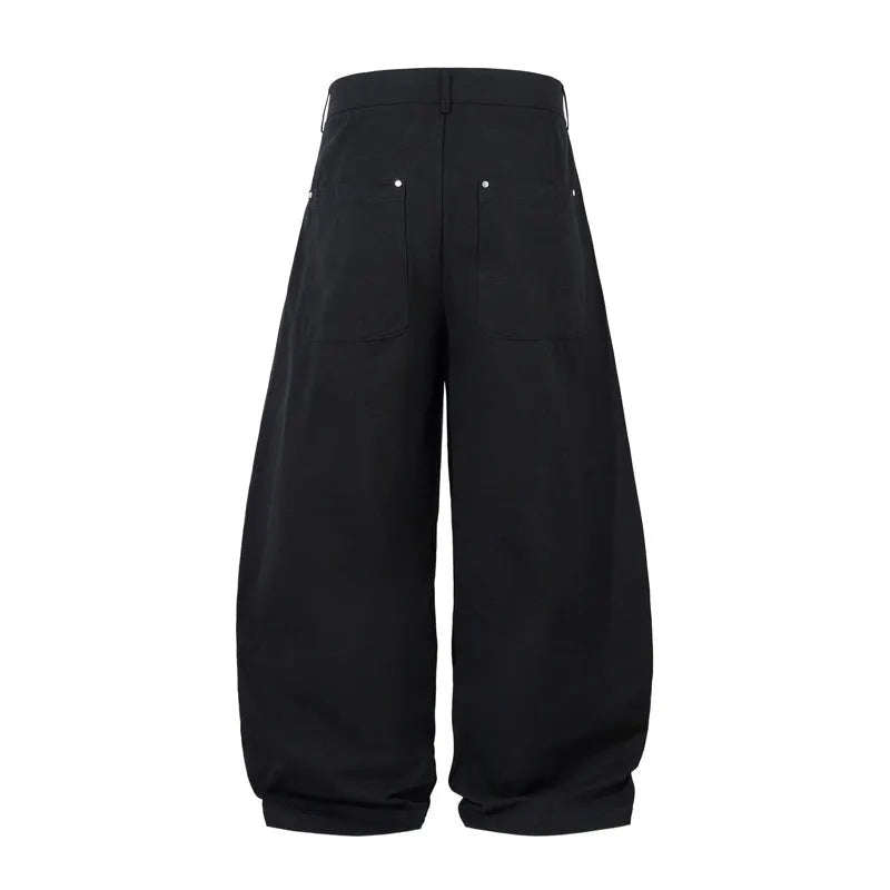 Men's black pleated machete casual trousers with a loose wide-leg fit on a neutral background.