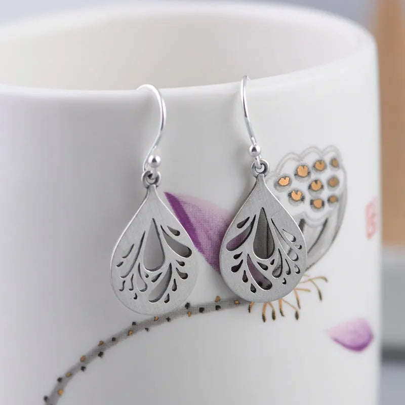 Pair of silver retro hollow water drop earrings with a hand-ground finish.