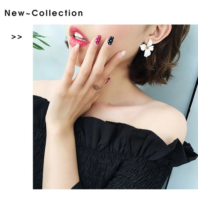 A pair of pink and white flower-shaped stud earrings with butterfly backs on a white background.