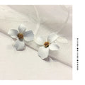 A pair of pink and white flower-shaped stud earrings with butterfly backs on a white background.