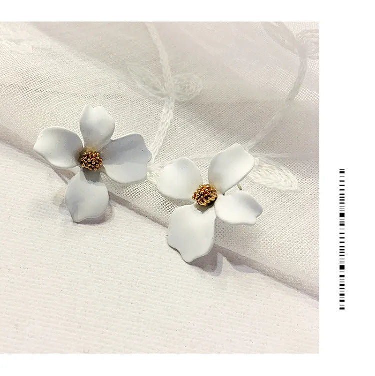 A pair of pink and white flower-shaped stud earrings with butterfly backs on a white background.
