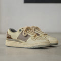 Beige low-top skateboard shoes with microfiber uppers, round toe, and lace-up closure on solid background