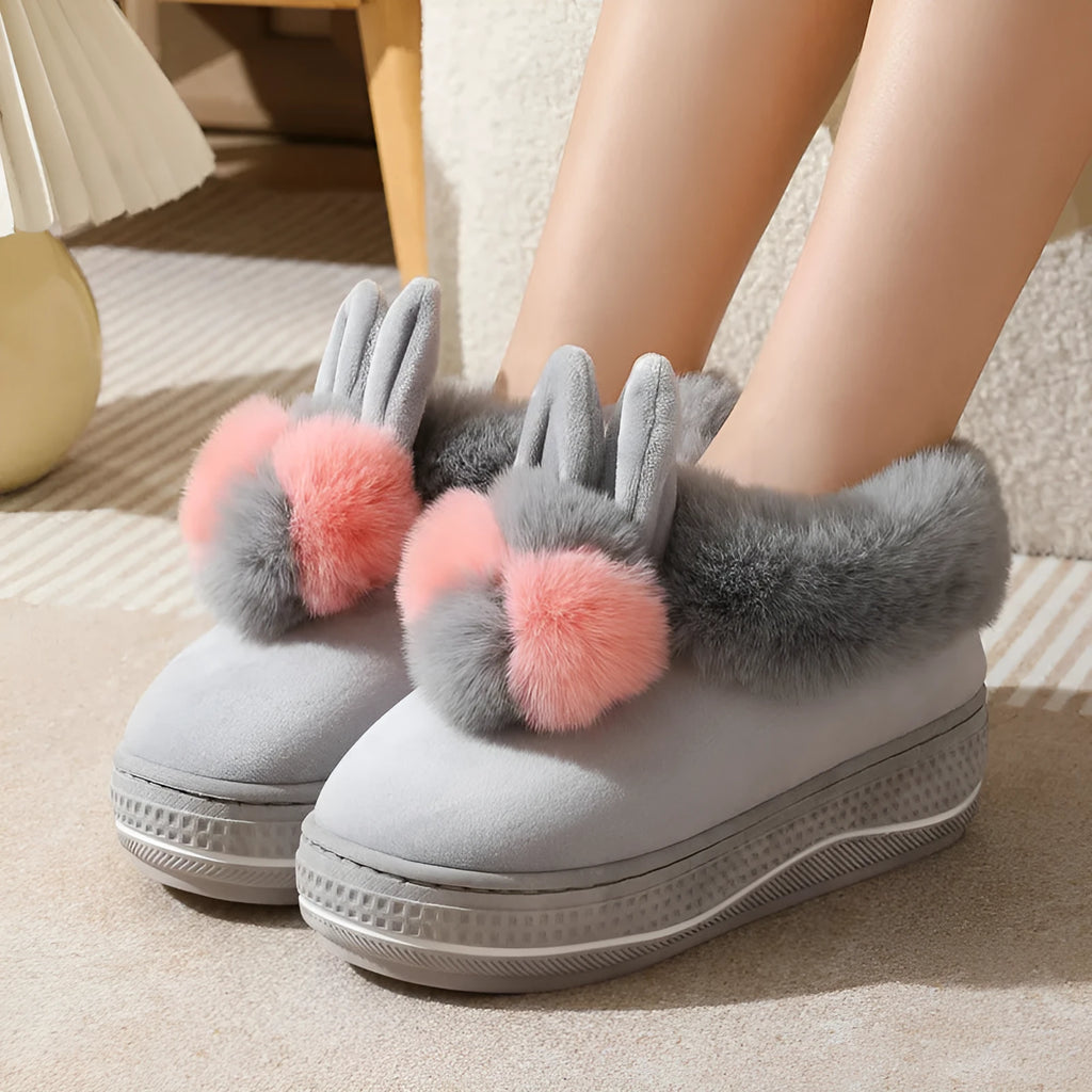 A pair of grey high heel winter slippers with a thick sole and plush upper, shown on a white background.