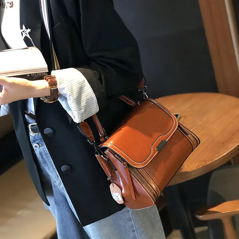 Women's brown genuine oil wax leather messenger bag with double shoulder straps and visible sewing lines