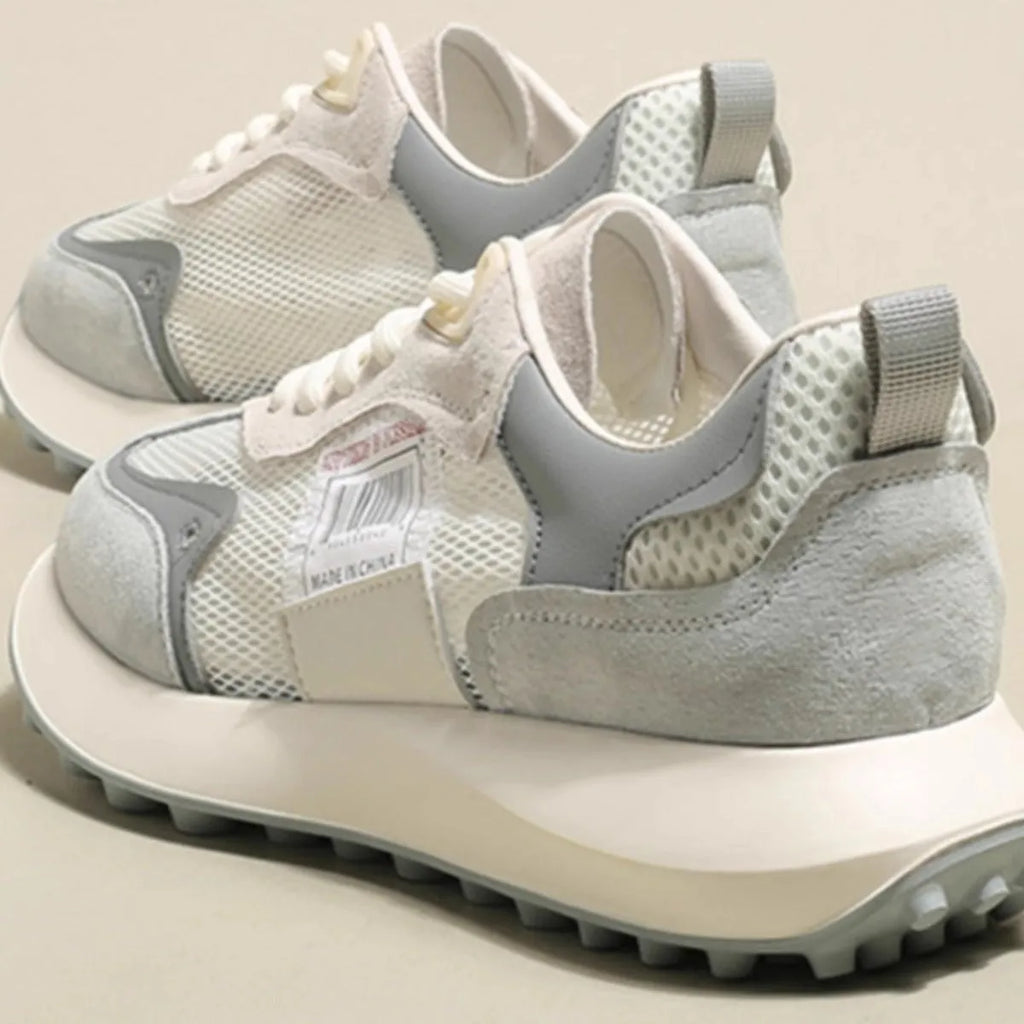 Women's grey and pink low-top retro sneaker with round toe and flat rubber sole.